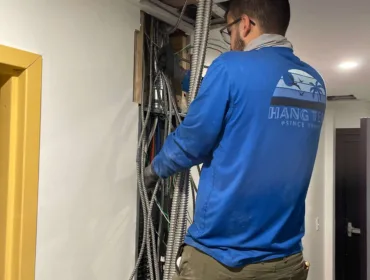 A skilled licensed & insured electrician diligently working on a room's wall