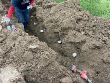 Trusted electrician working on excavated ground for electrical lines