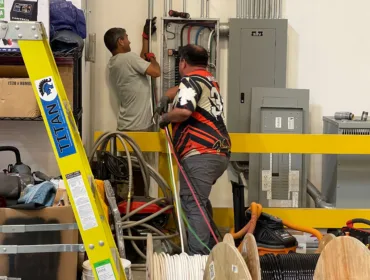 Electricians working on power box